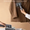 2-in-1 handheld garment steamer and iron, used for vertical steaming a blazer and horizontal ironing.